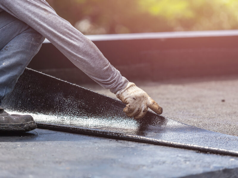 Asia worker installing tar foil on the rooftop of building. Waterproof system by gas and fire torching