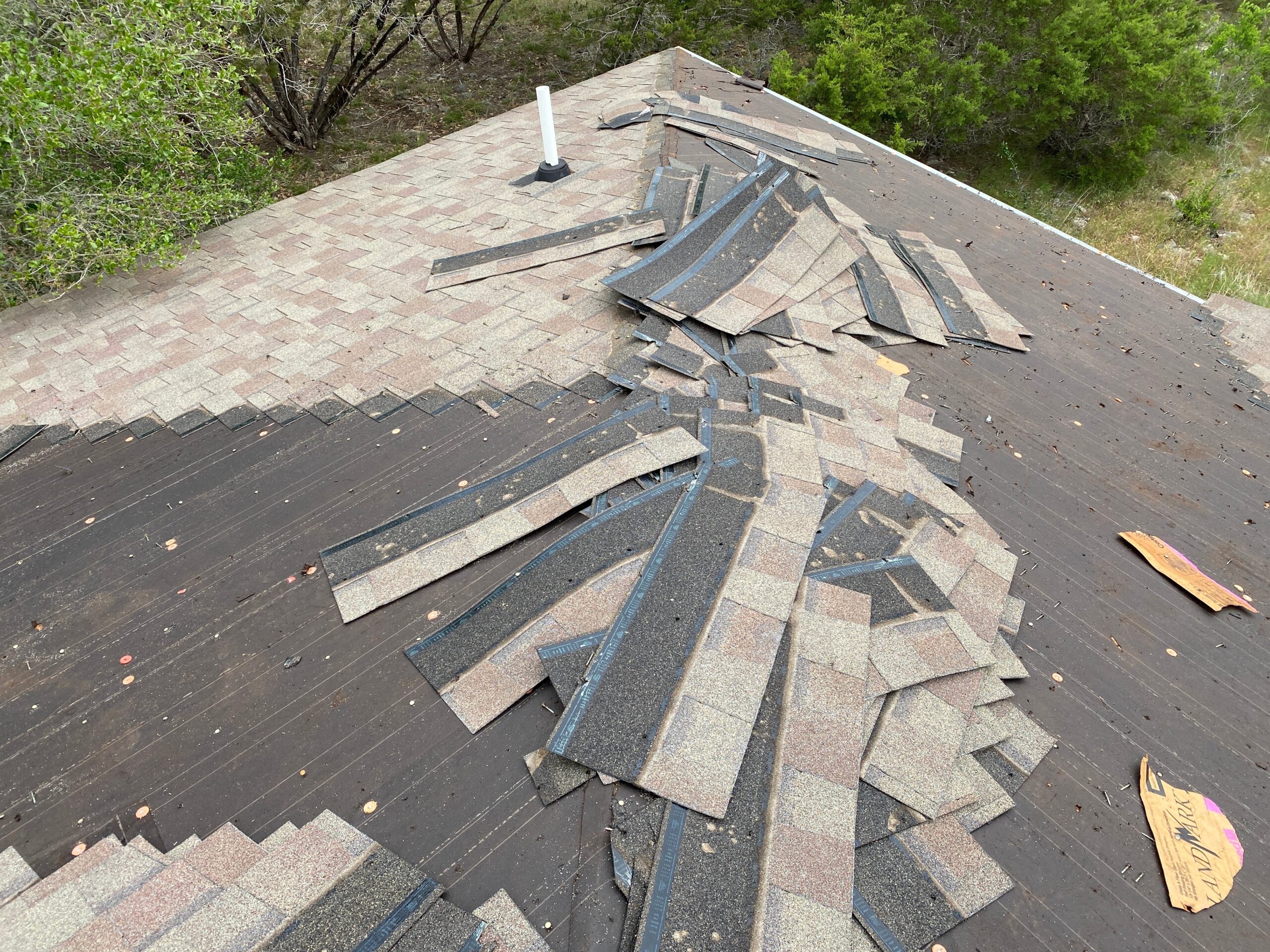 Removal of asphalt shingles during a professional re-roofing project in Arizona