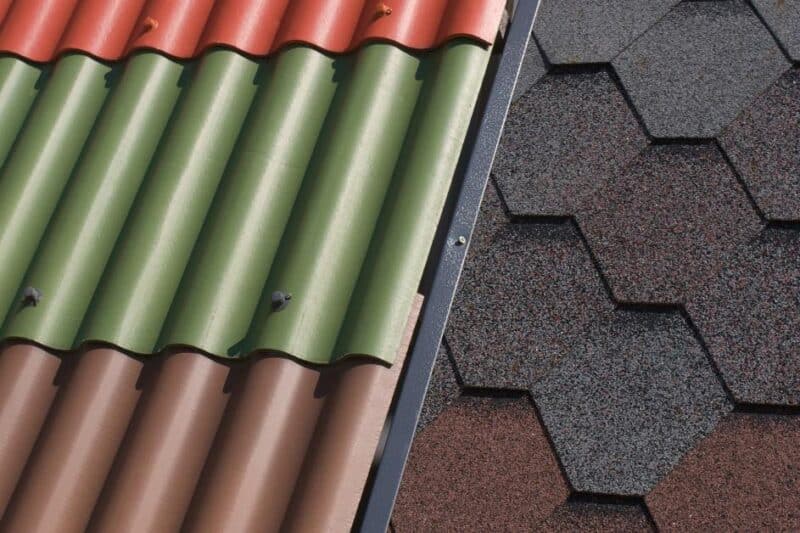 A sample board displays colorful corrugated metal roof panels beside textured hexagonal asphalt shingles for comparison.